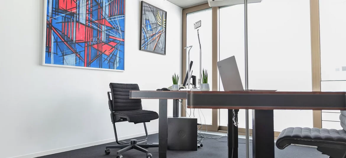 Zwei höhenverstellbare Schreibtische mit schwarzen Stühlen und modernen Lampen im lichtdurchfluteten Büro "Austausch" (beispielhafte Einrichtung).