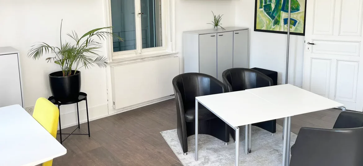 Helles Private Office Natureck bei CoWirken Schorndorf mit modernem Schreibtisch, Besprechungstisch, Pflanzen, Regalen und großen Fenstern mit Blick ins Grüne.