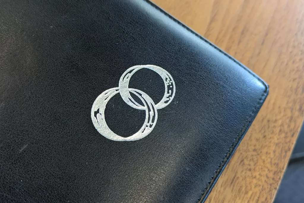 Schwarzes Stammbuch mit Ehering-Symbol auf einem Holztisch bei einer standesamtlichen Trauung in Schorndorf.