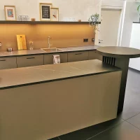 Voll ausgestattete Gemeinschaftsküche im Untergeschoss von CoWirken Schorndorf mit großer Kücheninsel, integriertem Stehtisch und modernem Design.